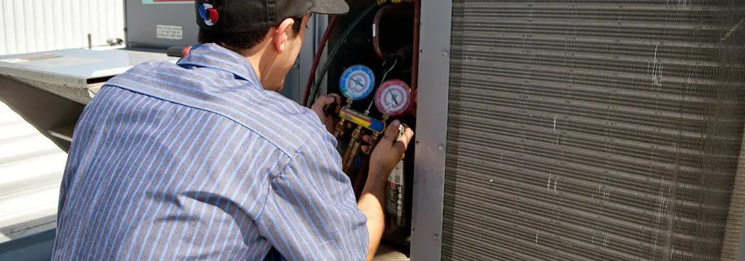HVAC technician servicing a condenser unit in Vermilion