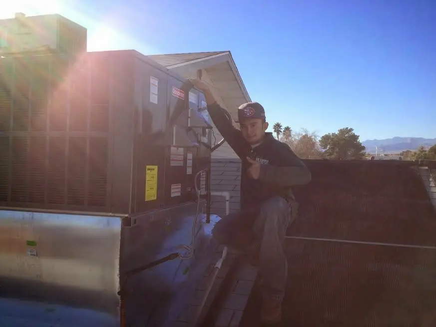 HVAC technician performing Heat Pump Repair on a rooftop unit in Vermilion